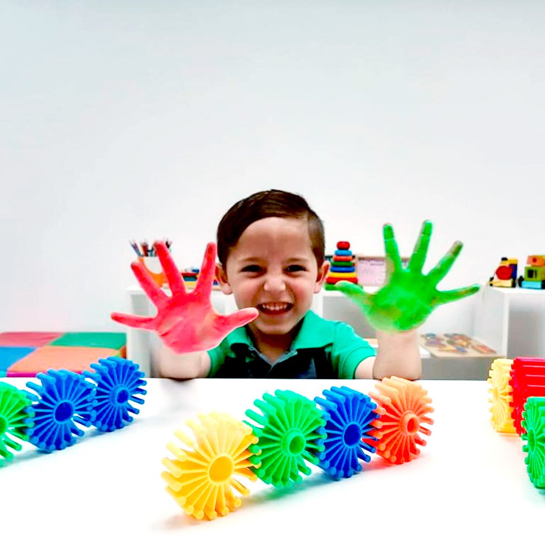 niño feliz con manos pintadas